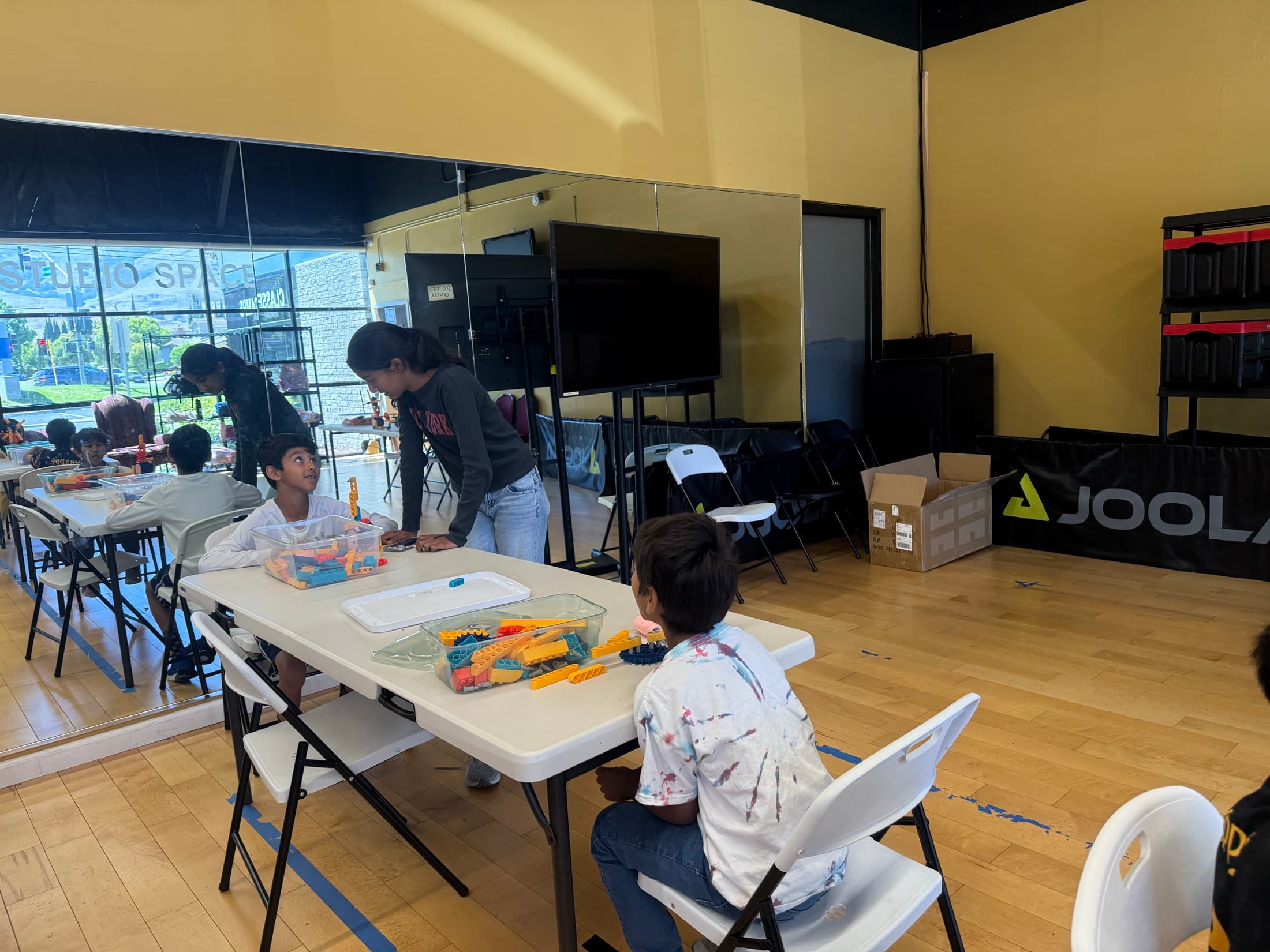 A child assembling colorful construction pieces at an activity table