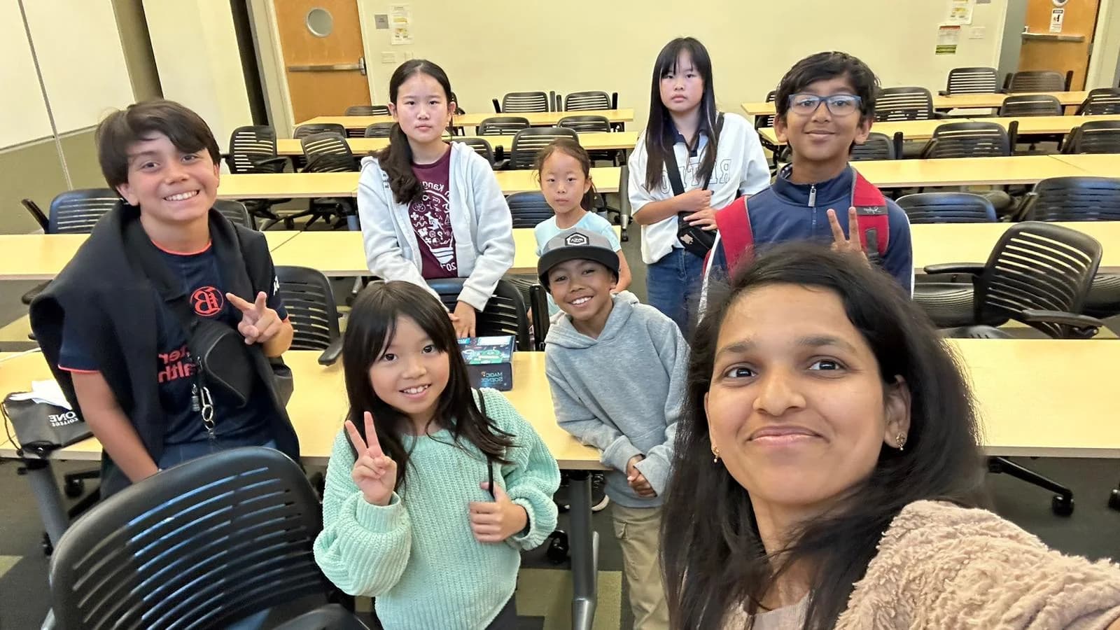 Children and an educator smiling together after a STEM session